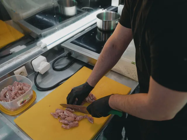 Higiéniai kesztyűben dolgozó szakember a HACCP-előírások szerint kezeli az alapanyagot